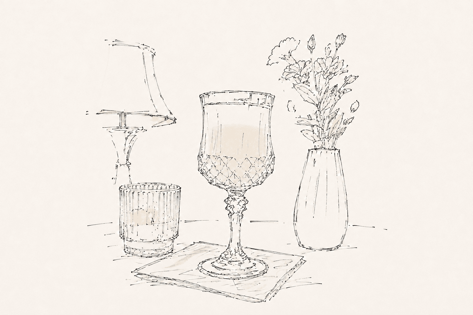 A line-art cocktail in a crystal glass beside a candle and flowers.